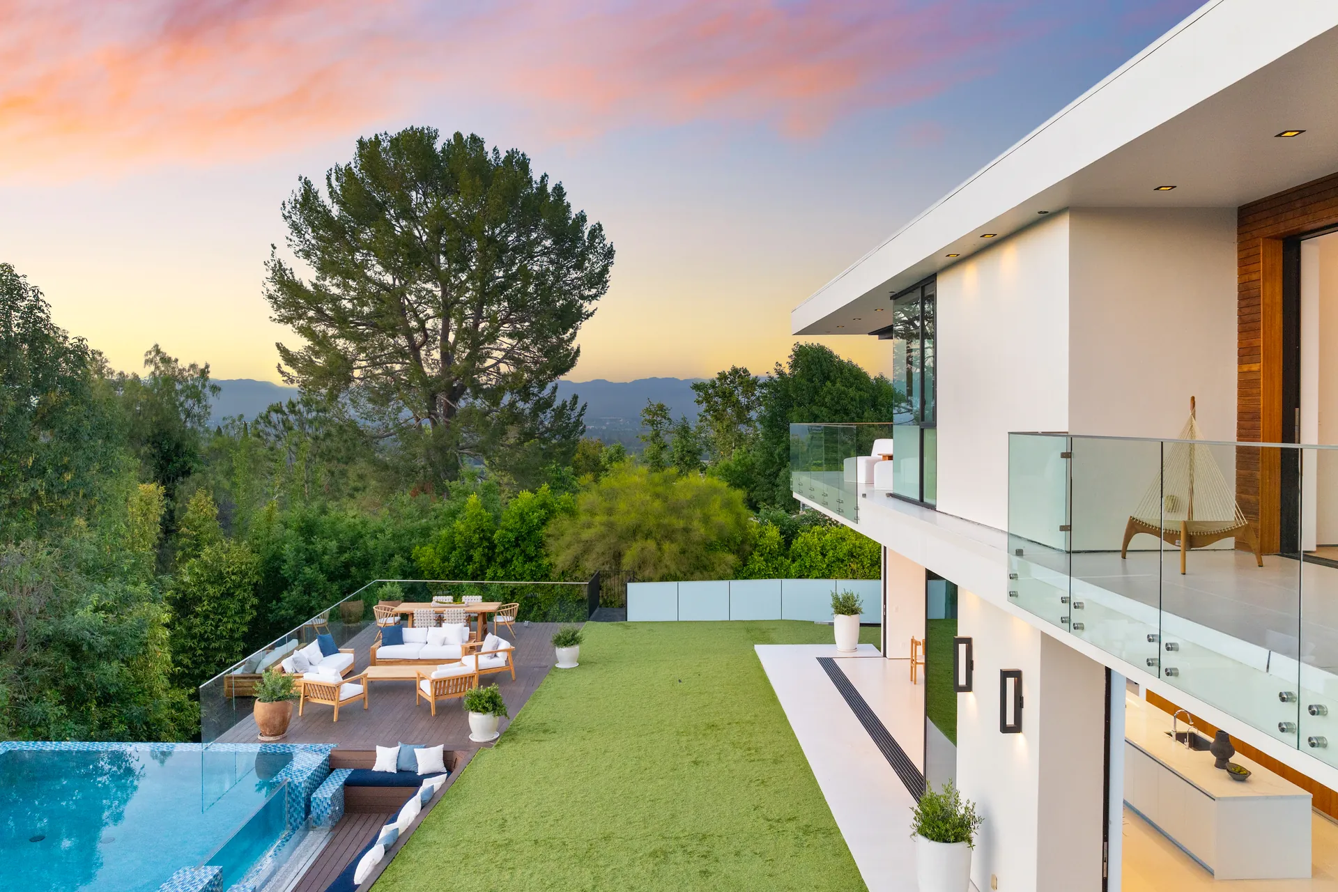 Haus mit Rasen, Glasbrüstung und Infinity-Pool über der Landschaft